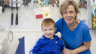 A young boy and a healthcare worker in a hospital ward.