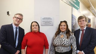 Two women and two men standing in front of a plaque reading "Cuan Dara Inpatient Addiction Treatment Centre"