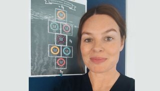 A female Advanced Midwife Nurse Practitioner smiling