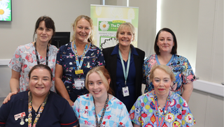 Seven healthcare workers looking at the camera and smiling.