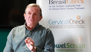 Man sitting in front of a pop up banner.