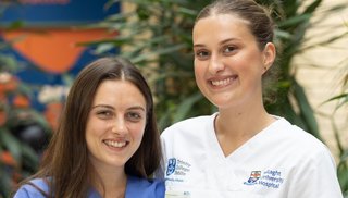 Two women smiling wearing medical scrubs
