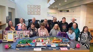 A group of people standing and smiling in a training centre setting