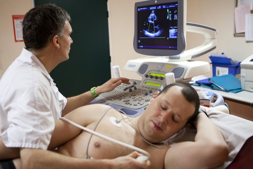 A cardiologist carrying out an echocardiogram on a patient