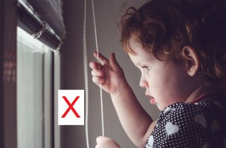 Girl holding pull-cord for blinds - these are a strangulation risk