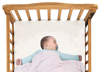 Baby in a cot with cellular blanket