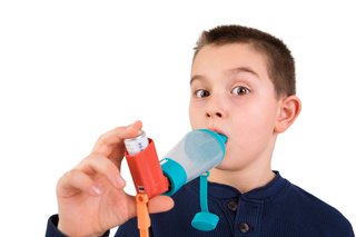 A child using a spacer device to inhale
