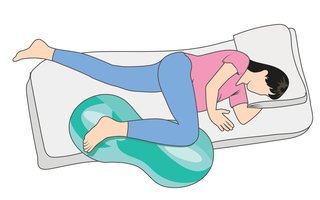 Illustration of a pregnant woman lying on their side on a mattress, with one leg resting on on a peanut ball.