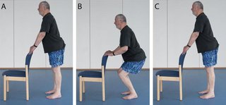 man holding back of chair and slowly bending knees then standing back up